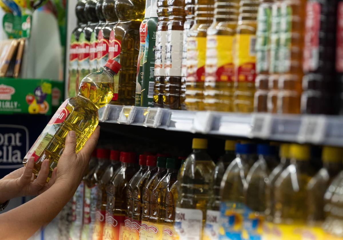 Botellas de aceite en un lineal de un supermercado.