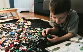 Un niño, haciendo una construcción con piezas de Lego