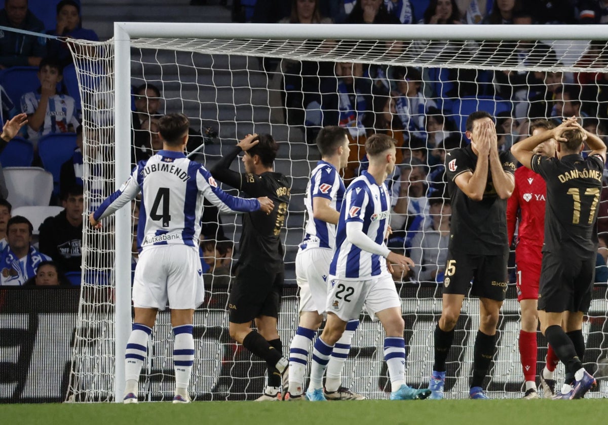 Los jugadores del Valencia se lamentan de una ocasión.