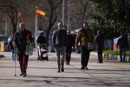 Un jubilado pensionista pasea por un parque.