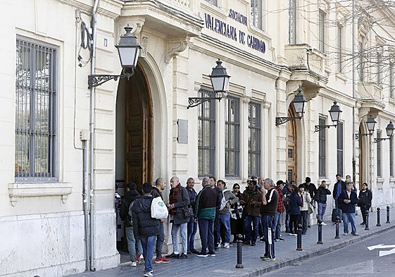 Cola de beneficiarios de ayuda en Casa Caridad.