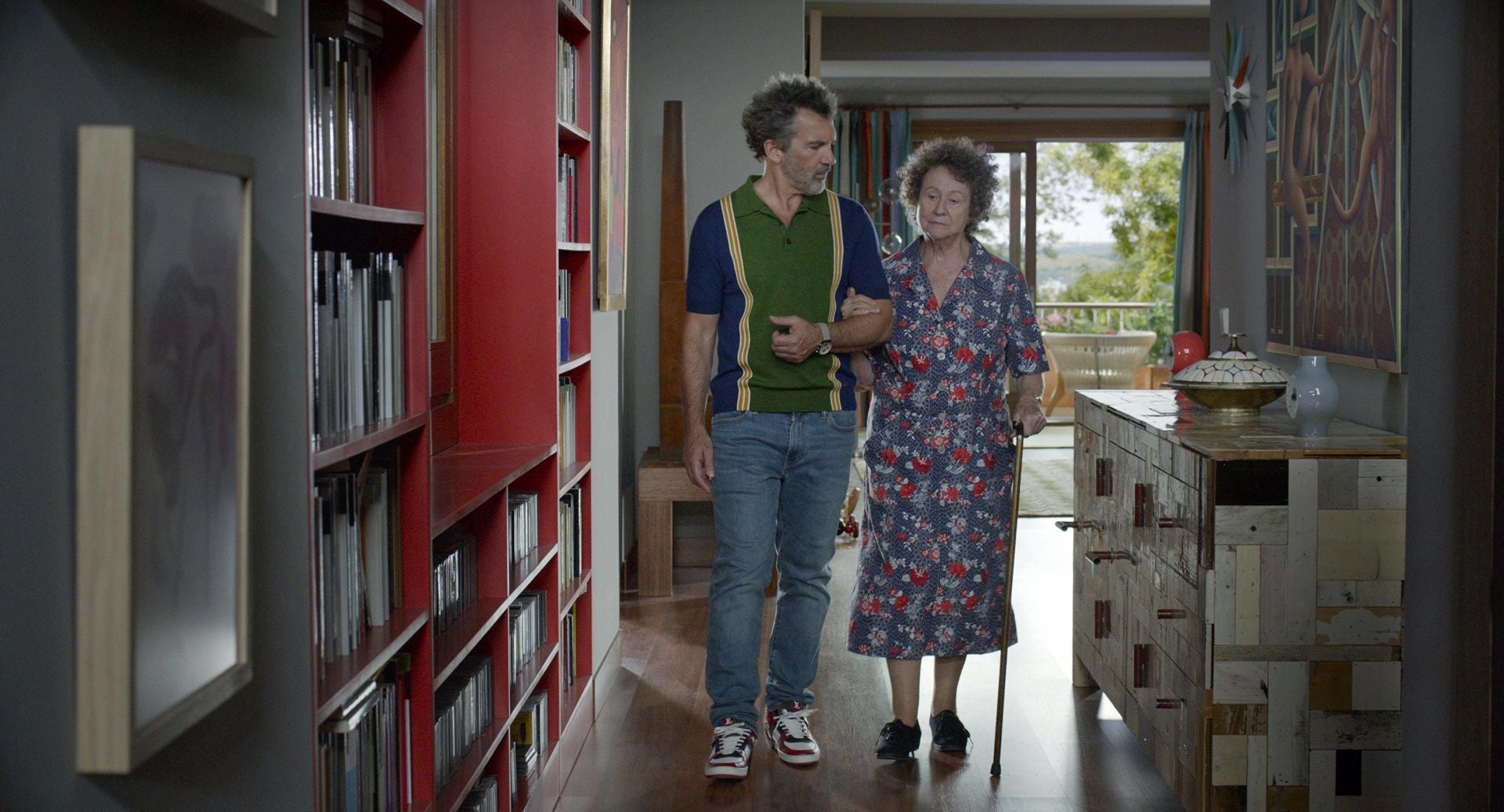 Imagen principal - Arriba, una escultura de Miquel Navarro (a la izquierda de la ventana) en 'Dolor y gloria'. En la foto del centro, la fachada de trencadís de Benimaclet, que sale en 'La mala educación'. En la tercera foto, Almodóvar sujeta el libro del valenciano Pau Gómez.