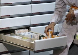 Una farmacéutica coloca varias cajas de medicamentos en una cajón, en una imagen de archivo.