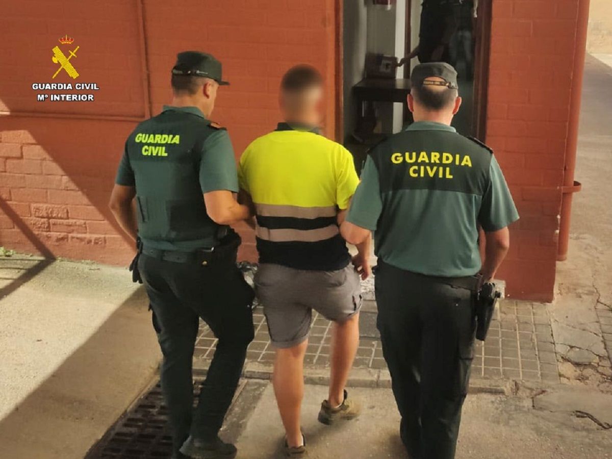 Dos agentes de la Beneméritca con el traficante, durante el arresto.