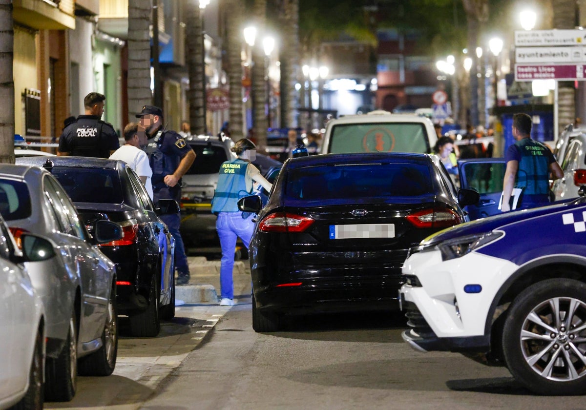 Guardias civiles y policías locales, el domingo, en la calle de Cheste donde tuvo lugar el crimen.