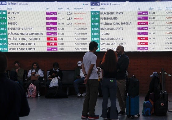 Varias personas esperan la salida de su tren en la estación de Atocha de Madrid el pasado domingo.