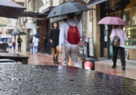 Varias personas protegiéndose de la lluvia.