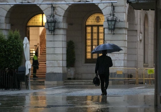 Un hombre se resguarda de la lluvia este miércoles en Valencia.