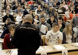 Un policía reparte los cuestionarios a los aspirantes a entrar en el cuerpo., en una imagen de archivo.