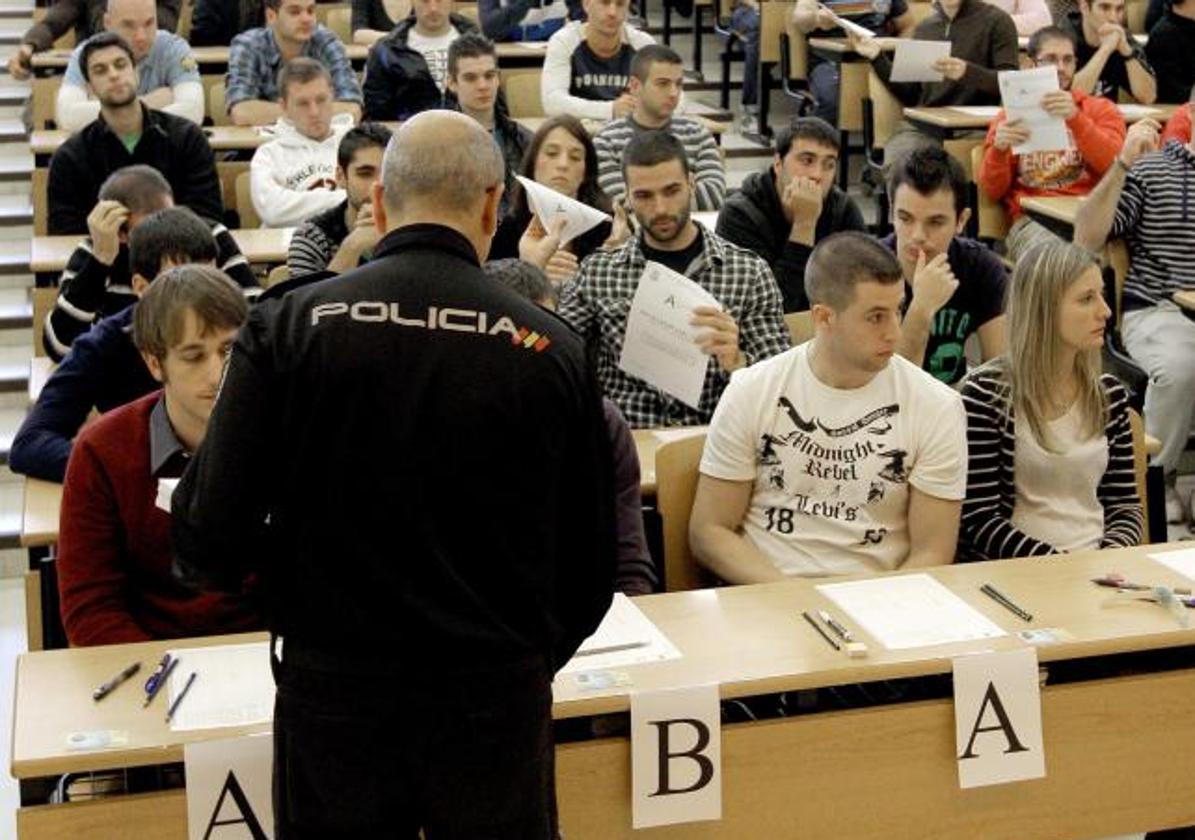 Un policía reparte los cuestionarios a los aspirantes a entrar en el cuerpo., en una imagen de archivo.