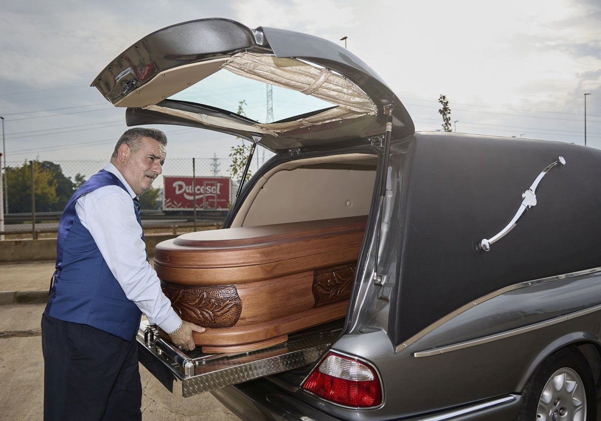 Javier Flores, conductor de la funeraria La Esperanza, traslada un féretro en Paiporta.