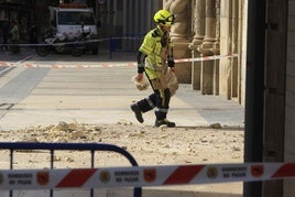 Un bombero retira cascotes caídos.