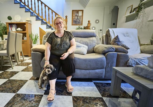 Encarni, junto a su perro en el salón de su casa.