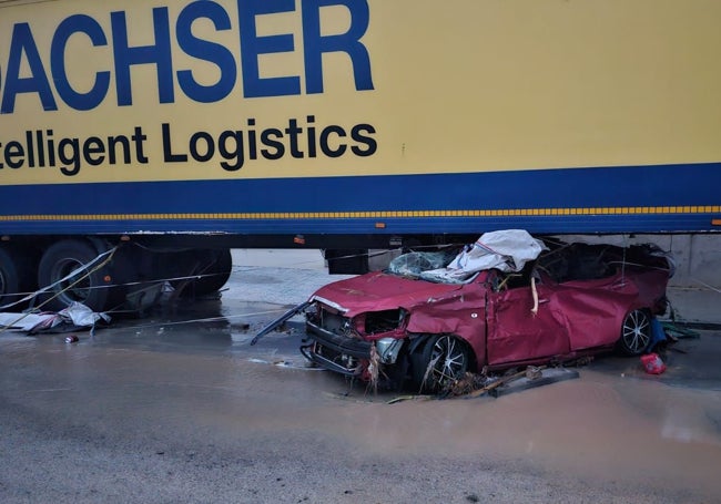 Coche aplastado bajo un camión en una zona industrial de Riba-roja.