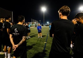 Los futbolistas del manises atienden a las indicaicones de su entrenador al inicio de un entrenamiento.