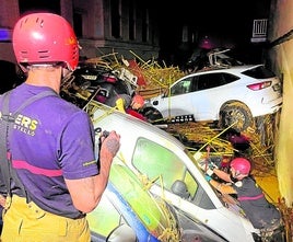 Dos bomberos juntoa a coches amontonados.