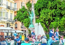 Personas sentads en una terraza de la plaza de la Virgen menos poblada de lo habitual.