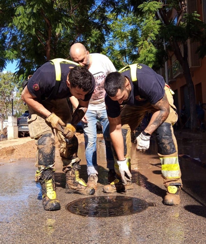 Imagen secundaria 2 - Los vecinos, ayudados por bomberos voluntarios llegados de Alcorcón y policías también voluntarios, limpian las calles del barrio y sacan agua.