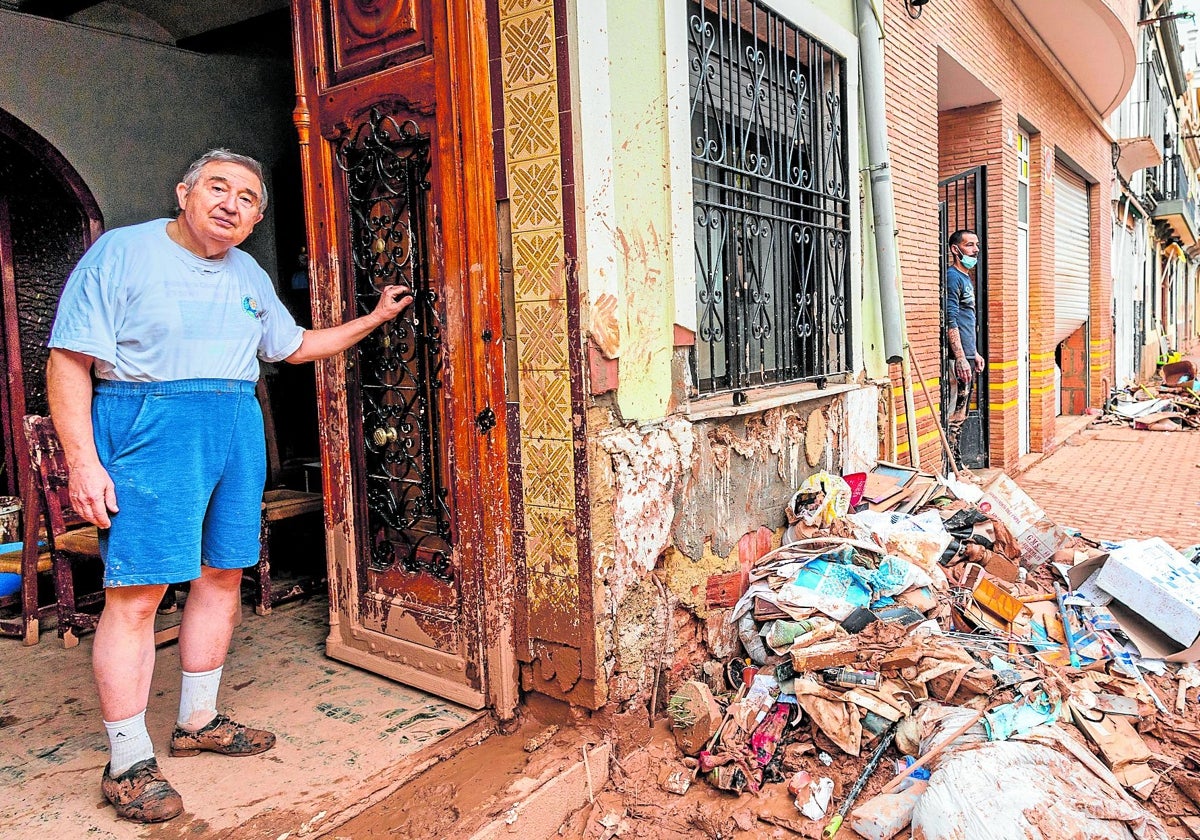 Un vecino de Aldaia en la puerta de su casa llena de barro.