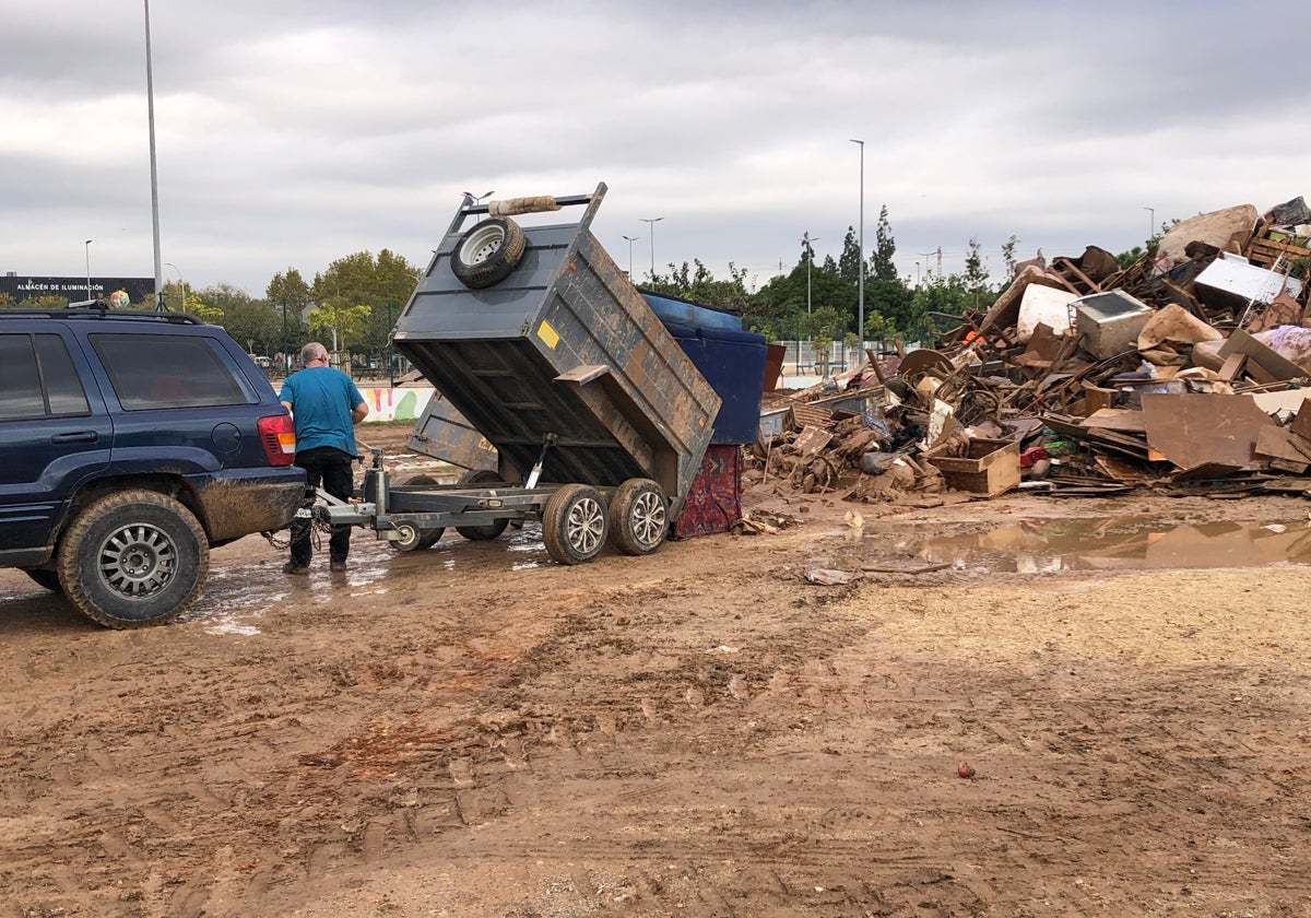 Un voluntario vuelca basura en uno de los municipios afectados.