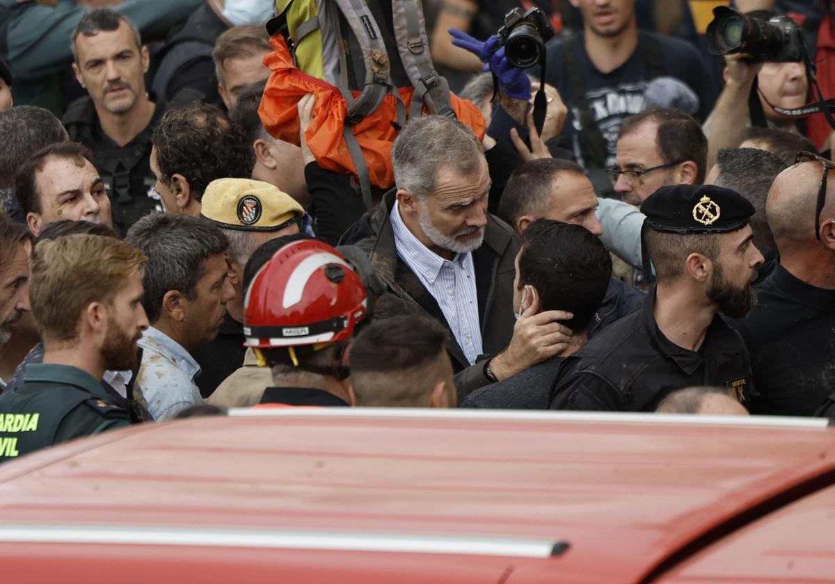 El rey Felipe habla con uno de los vecinos afectados durante su visita a Paiporta este domingo.