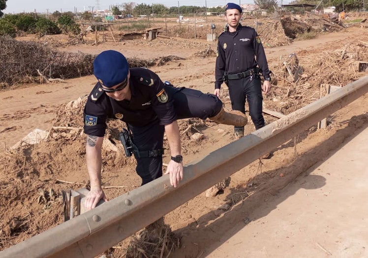 Dos policías de la Unidad Aérea acceden a una zona inundada para auxiliar a un vecino.