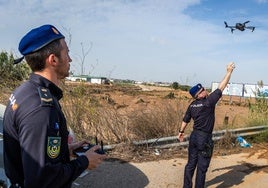 Dos agentes de la Unidad Aérea de la Policía Nacional, este martes, en una carretera de Paiporta.