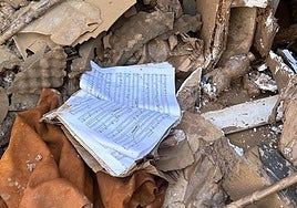 Una partitura manchada de barro sobre una pila de escombros.