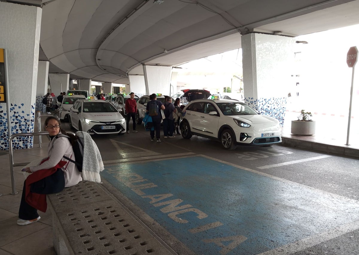 Imagen secundaria 1 - Arriba, la cinta que impide el paso a la boca de metro. Los taxis, una de las alterativas al autobús.