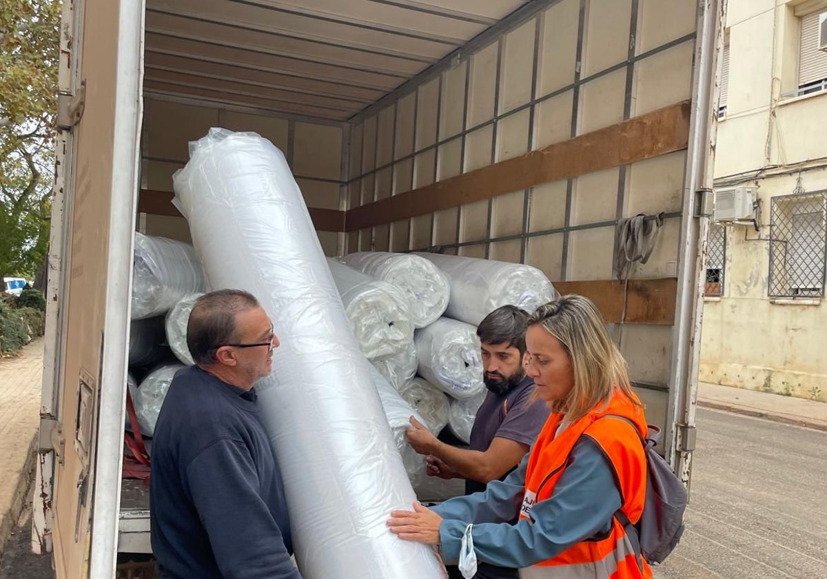 La edil Paula Llobet, con los transportistas de colchones y camas.