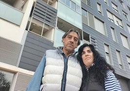 Alfonso y Leticia, frente a su edificio, mientras su coche está sepultado por barro.