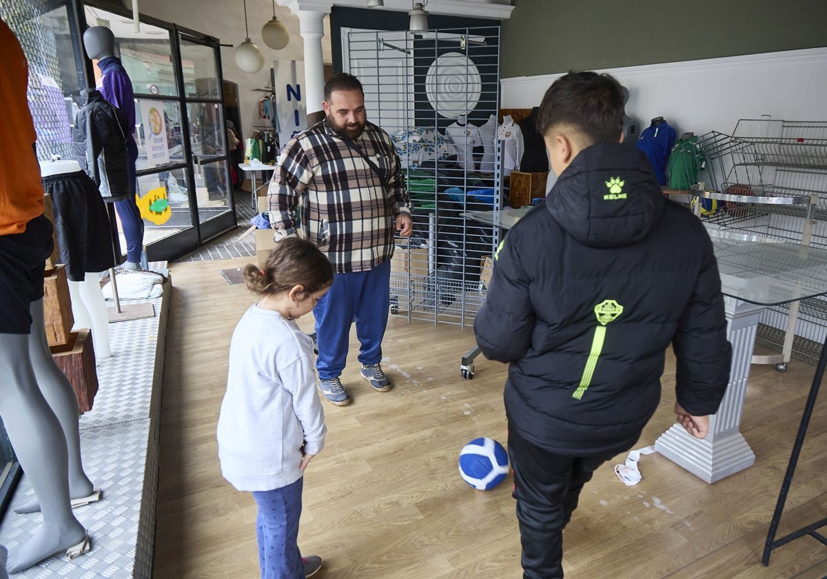 Daniel, vecino del Xenillet, con dos de sus hijos en la tienda del Evangélico.