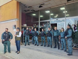 Agentes de la Guardia Civil y una de las personas auxiliadas en la puerta del bazar.