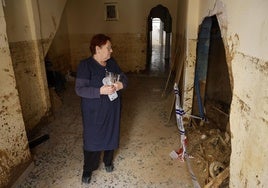 María Reche observa el gran boquete que se ha abierto hacia la vivienda contigua.