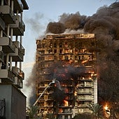Un bombero ataca las llamas desde una autoescalera.