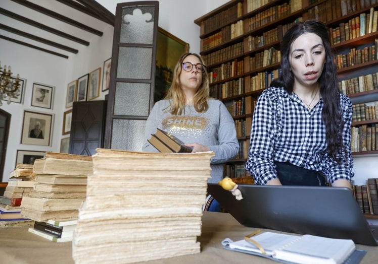 Gloria e Iabel trasladan a soporte digital el contenido de la biblioteca.