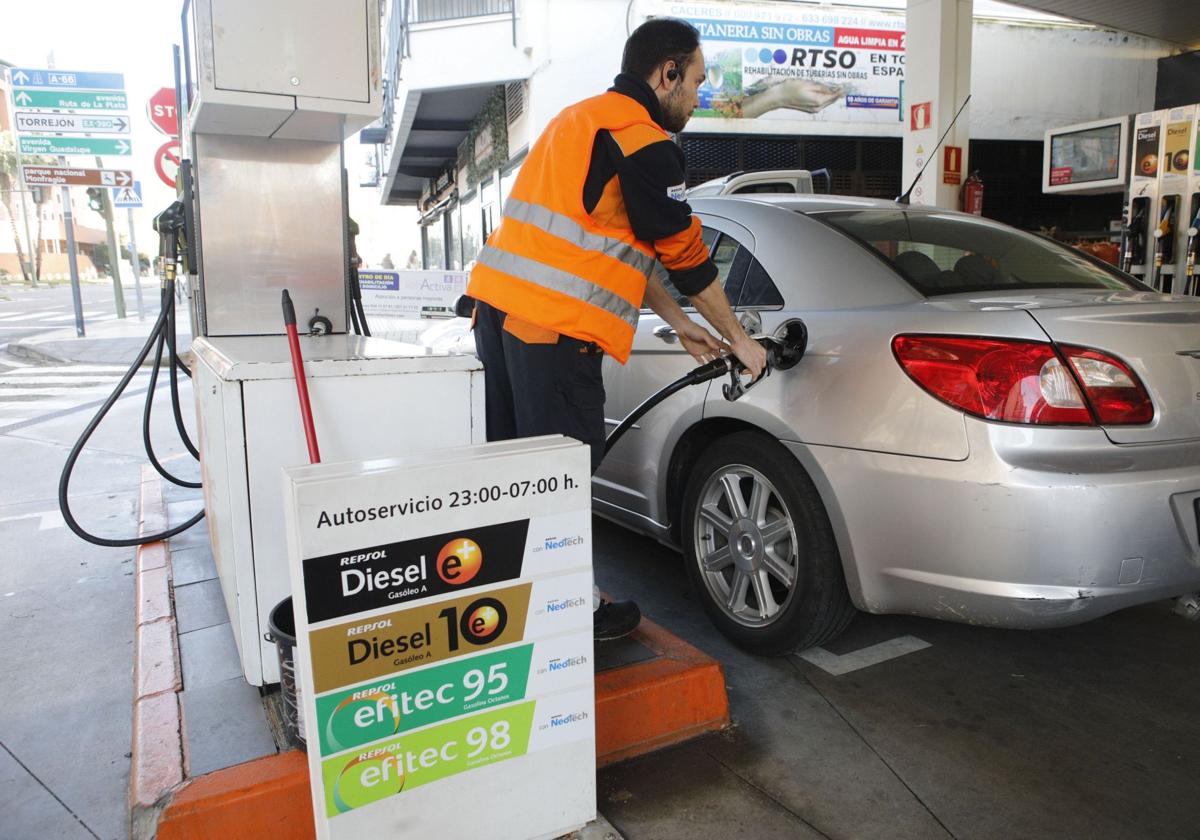 Un operario de una gasolinera repostando.