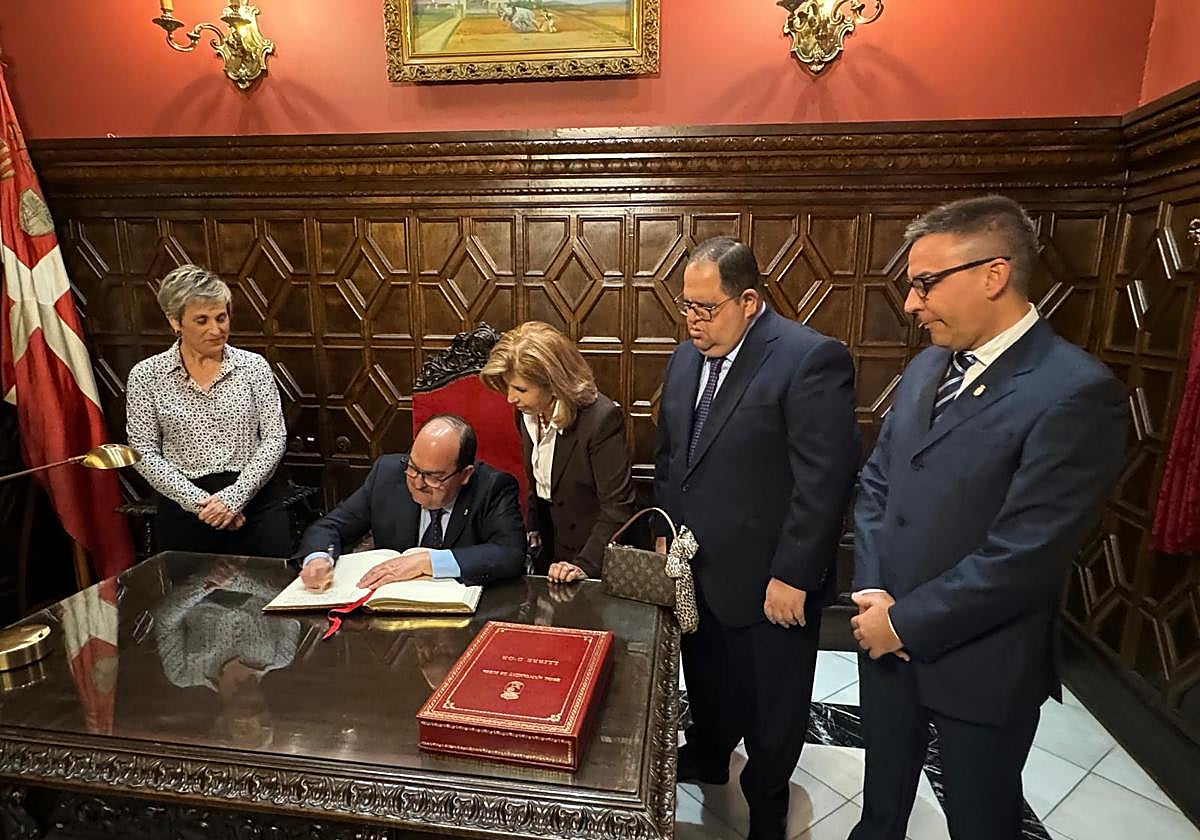 González firma en el libro de oro de la ciudad.