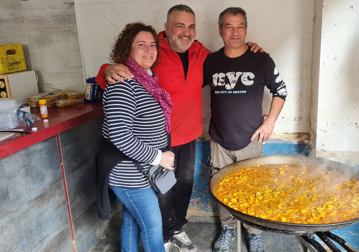 Imagen principal - En las dos primera fotos, Edi, de rojo, junto a los voluntarios que le ayudan a hacer la comida y en la inferior el estado del mobiliario de la cocina de su bar tras la barrancada. 