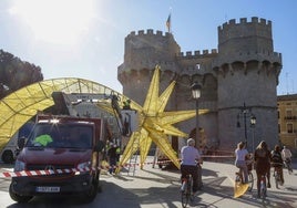 Operarios colocan la estrella de Navidad en el centro de Valencia.