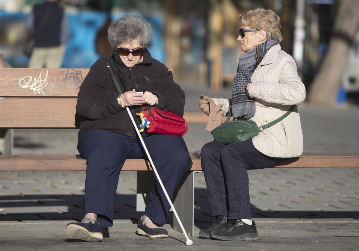 Dos ancianas sentadas en un banco en Valencia.