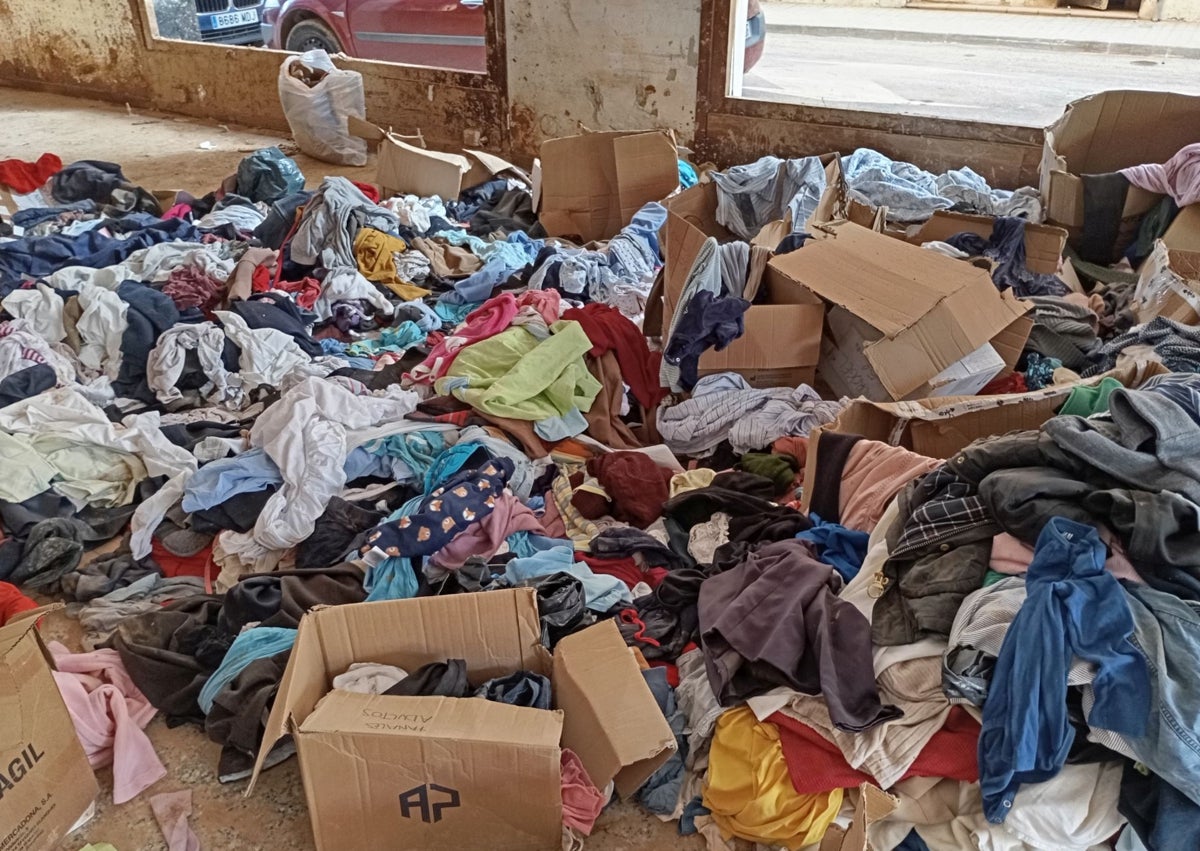 Imagen secundaria 1 - De arriba a abajo: material en la plaza de la Fusta de Benetússer, ropa abandonada en un local de Sedaví y productos en la calle Horta del primer municipio