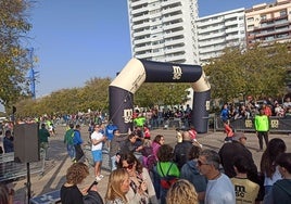 Un grupo de participantes cruza la meta del minimaratón en el Paseo de la Alameda.