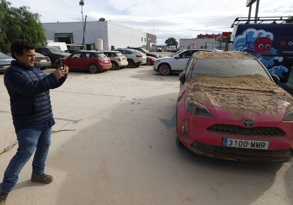 El gerente de un concesionario fotografía un vehículo arrasado por el temporal.