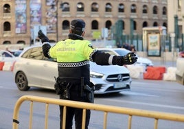 Un policía redirige el tráfico en el centro de Valencia este viernes.