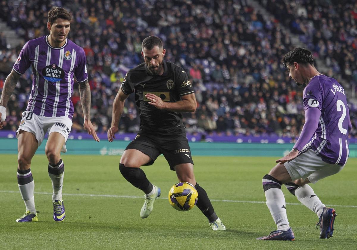 Luis Rioja ante dos jugadores del Valladolid.