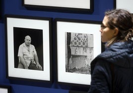 Una mujer, delante de dos fotografías de Cualladó.