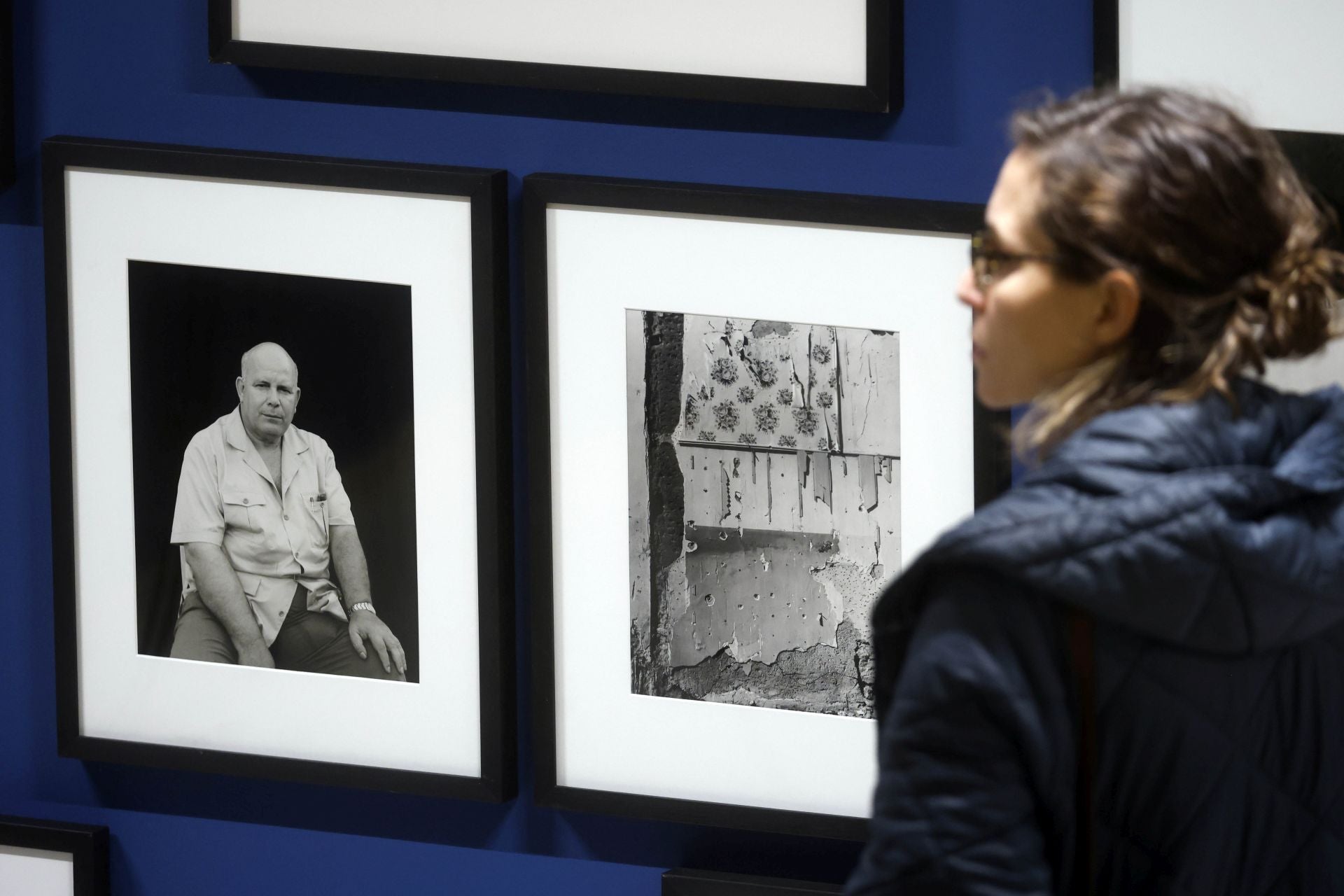 Una mujer, delante de dos fotografías de Cualladó.