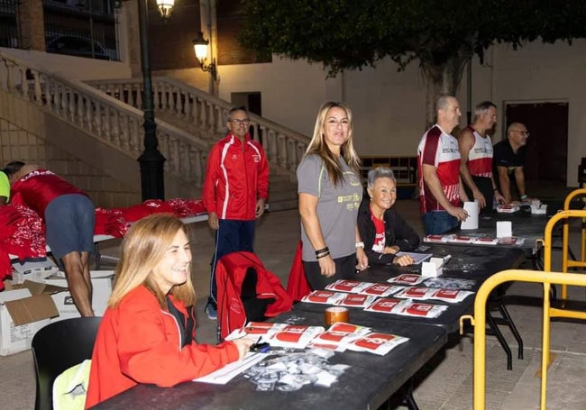 Miembros del Club Atletismo de Cullera preparando la inscripciones de la Volta a Peu