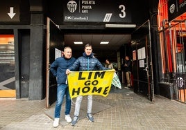 Un accionista del Valencia posa con una pancarta con el lema Lim Go Home antes de entrar en la Junta.